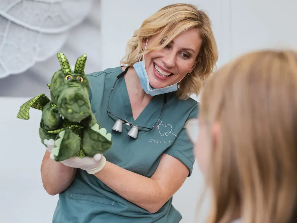 Zahnärztin mit Kuscheltier im Behandlungszimmer