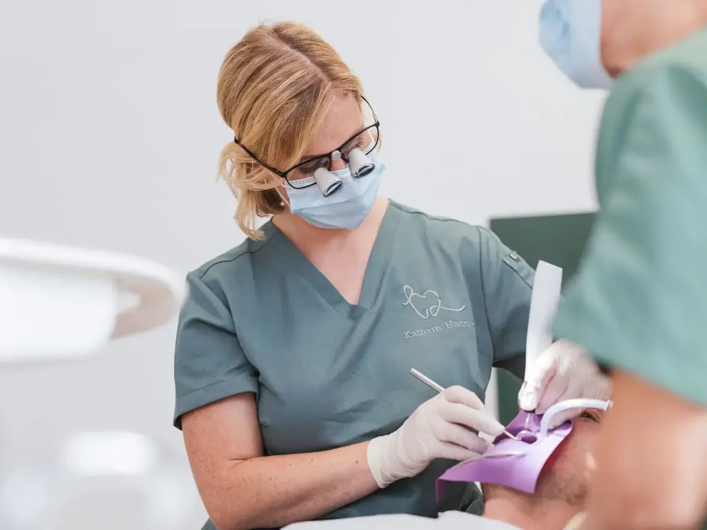 Zahnärztin mit Schutzbrille bei Behandlung